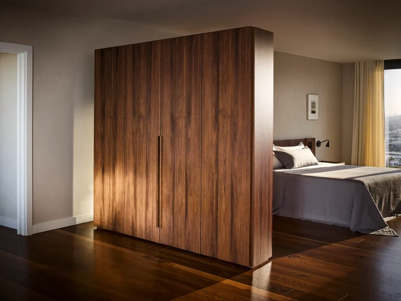 Kleiderschrank aus Nussbaum mit bündigen Fronten in einem ruhigen Schlafzimmer